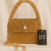 a gold beaded purse with a black tag