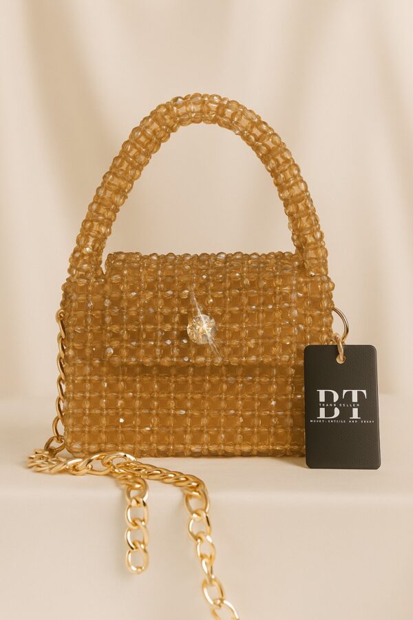 a gold beaded purse with a black tag
